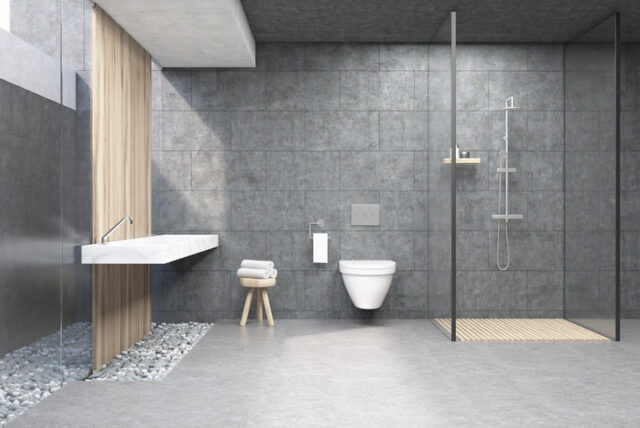 Minimalistiske badeværelseselementer med natursten og stor grå fliser.