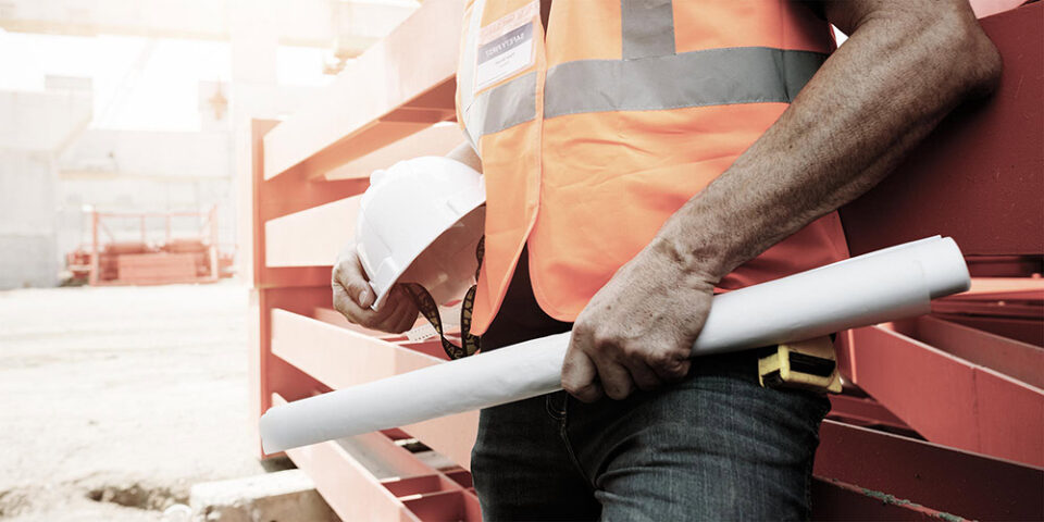 Bygningsrådgiver i orange vest og med hvid hjelm under armen, klar til at give byggerådgivning.
